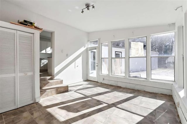 unfurnished living room featuring vaulted ceiling and a wealth of natural light