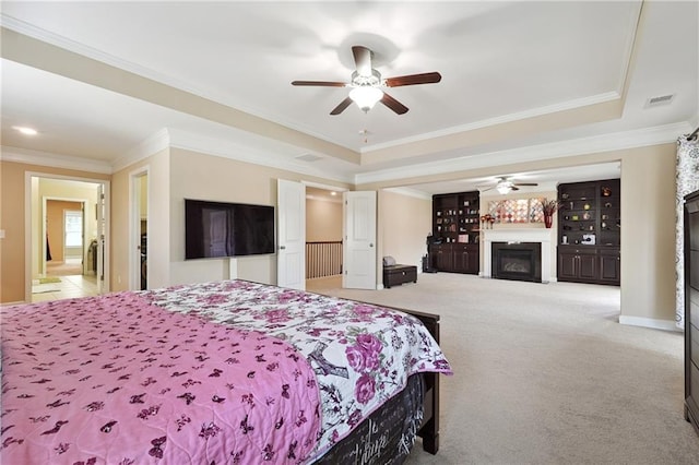 915 Elmsbrook Ln, Alpharetta, GA 30004 - bedroom featuring a glass covered fireplace, carpet, ornamental molding, a tray ceiling, and ceiling fan