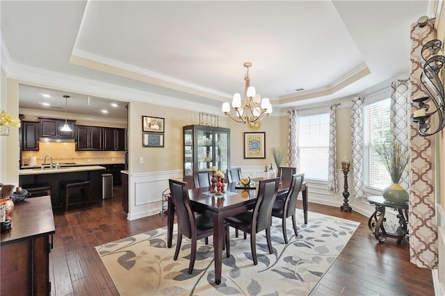915 Elmsbrook Ln, Alpharetta, GA 30004 - dining area with a raised ceiling, a chandelier, dark wood-type flooring, crown molding, and a wainscoted wall