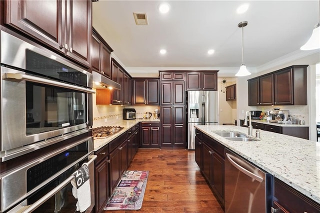 915 Elmsbrook Ln, Alpharetta, GA 30004 - kitchen featuring appliances with stainless steel finishes, crown molding, under cabinet range hood, dark wood finished floors, and light stone countertops