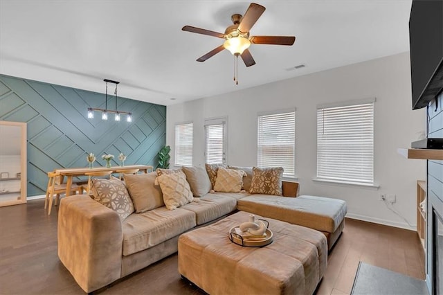 living room featuring dark wood-type flooring and ceiling fan