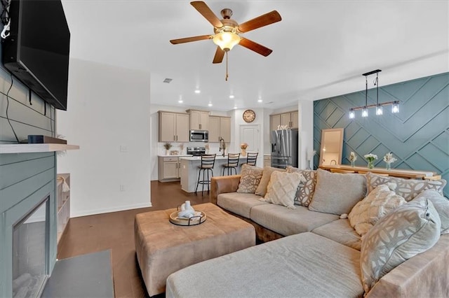 living room with ceiling fan, dark hardwood / wood-style floors, and sink