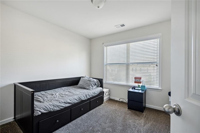 carpeted bedroom featuring multiple windows, visible vents, and baseboards