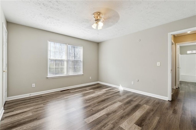 empty room featuring a ceiling fan, wood finished floors, baseboards, and a textured ceiling