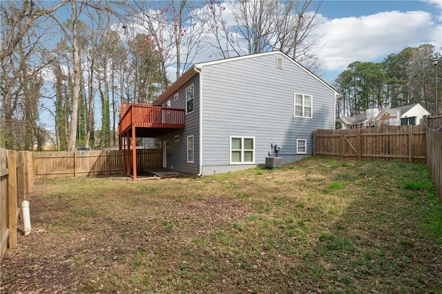 exterior space featuring a wooden deck, a lawn, central AC, and a fenced backyard