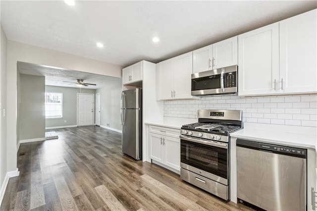 kitchen featuring backsplash, stainless steel appliances, light countertops, and wood finished floors