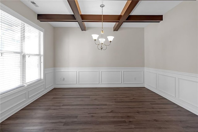 empty room featuring a wealth of natural light, a chandelier, beamed ceiling, and dark hardwood / wood-style flooring