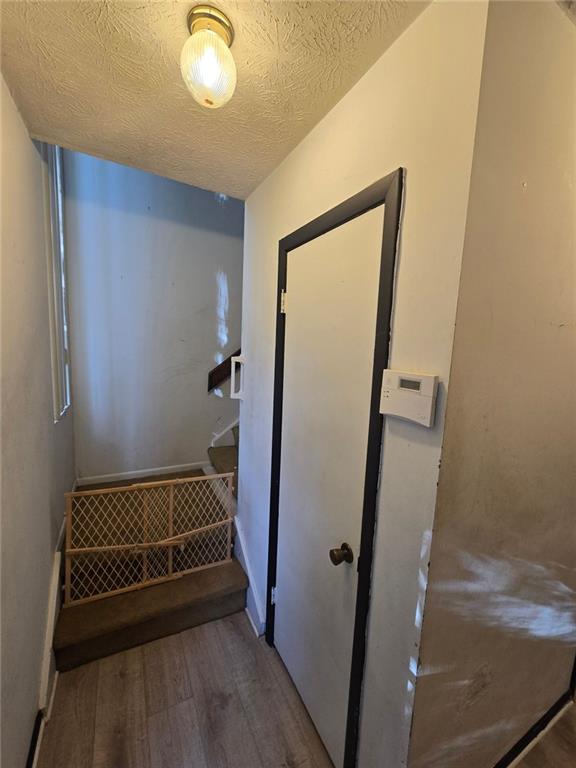 1297 Tree Creek Ct, Clarkston, GA 30021 - stairway with wood finished floors and a textured ceiling
