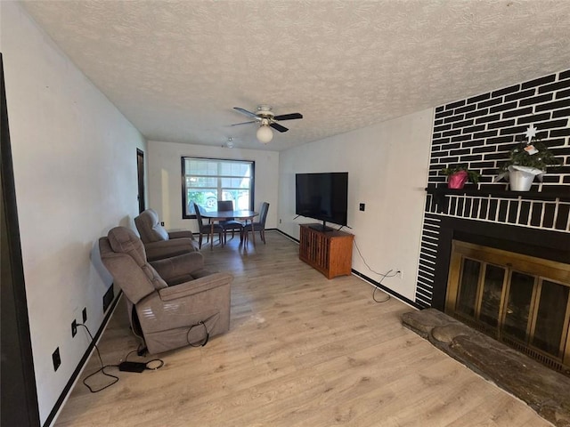 1297 Tree Creek Ct, Clarkston, GA 30021 - living area with wood finished floors, a large fireplace, a textured ceiling, and a ceiling fan