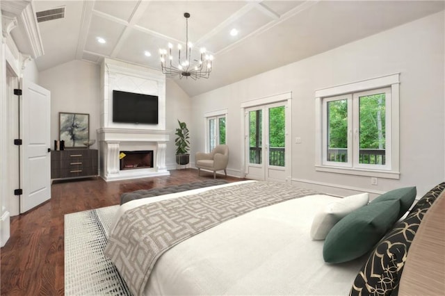 bedroom with multiple windows, dark hardwood / wood-style flooring, a notable chandelier, and a fireplace