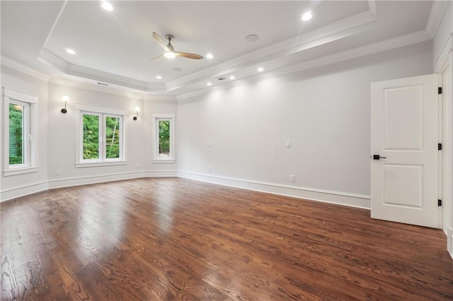 empty room featuring crown molding, ceiling fan, dark hardwood / wood-style floors, and a raised ceiling