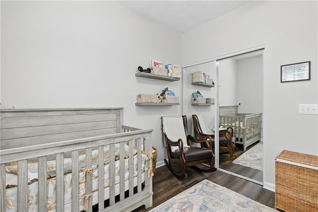 bedroom featuring a closet, baseboards, a textured ceiling, and wood finished floors