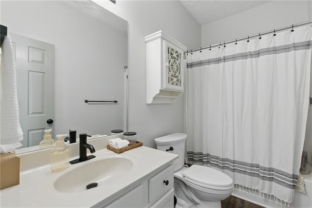 bathroom with toilet, vanity, and a textured ceiling