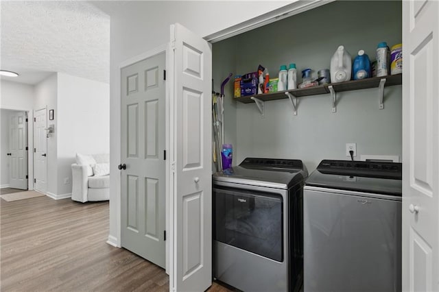 clothes washing area featuring baseboards, laundry area, separate washer and dryer, a textured ceiling, and dark wood-style flooring