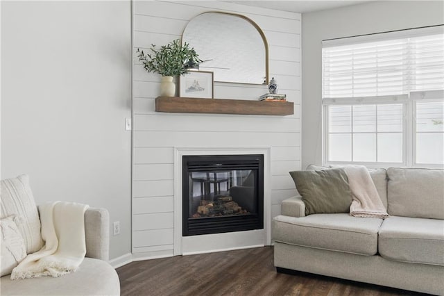 living area featuring a fireplace, baseboards, and dark wood-style flooring