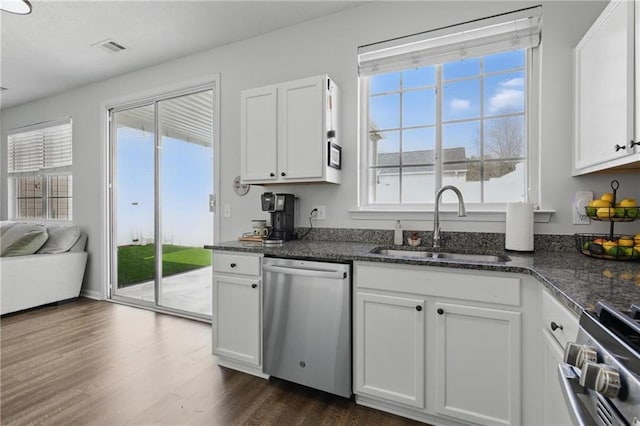 kitchen featuring visible vents, dark wood-style flooring, a sink, appliances with stainless steel finishes, and white cabinetry