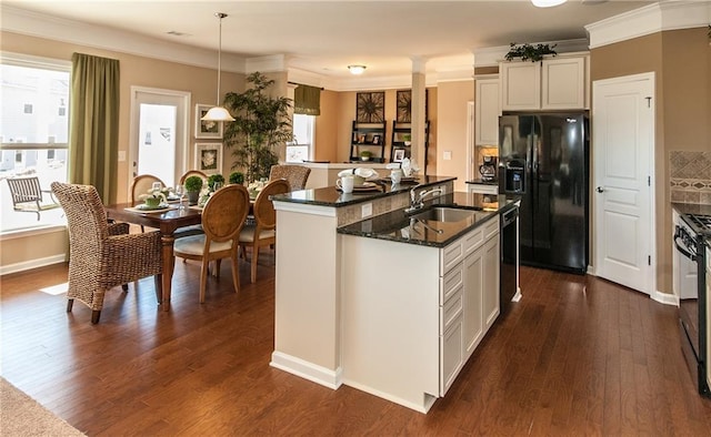 5110 Mulberry Pass Ct, Hoschton, GA 30548 - kitchen with black appliances, a kitchen island with sink, dark wood finished floors, dark stone countertops, and crown molding