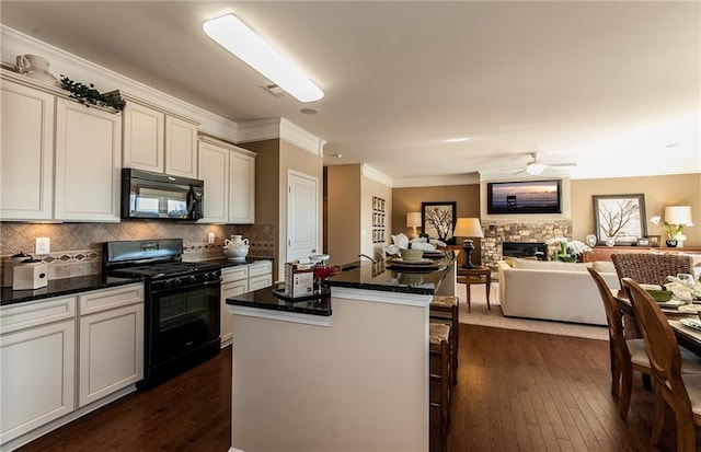 5110 Mulberry Pass Ct, Hoschton, GA 30548 - kitchen with black appliances, open floor plan, dark wood-style flooring, a kitchen island, and dark stone counters
