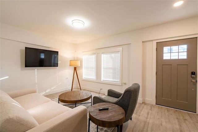 living area with light wood-style floors and baseboards