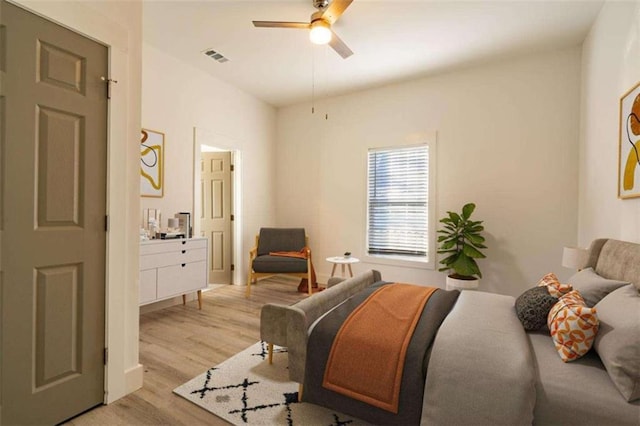 bedroom featuring visible vents, light wood-style flooring, ensuite bathroom, and a ceiling fan