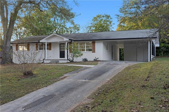 view of front facade with brick siding, an attached carport, concrete driveway, and a front yard