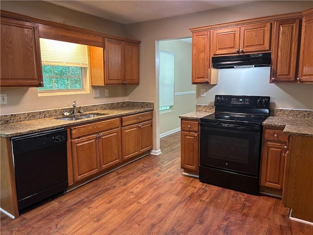 6536 Rebecca Lou Ln, Lithonia, GA 30058 - kitchen featuring black appliances, under cabinet range hood, a sink, dark wood-style floors, and brown cabinets