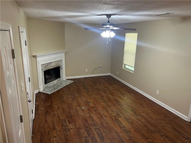 6536 Rebecca Lou Ln, Lithonia, GA 30058 - unfurnished living room featuring a textured ceiling, dark wood finished floors, ceiling fan, a premium fireplace, and baseboards
