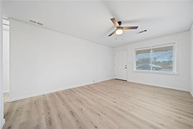 empty room featuring ceiling fan, crown molding, and light wood-type flooring