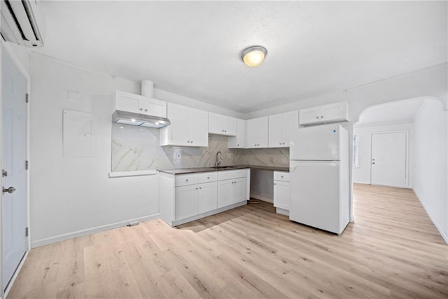 kitchen featuring backsplash, white cabinets, white refrigerator, sink, and light wood-type flooring