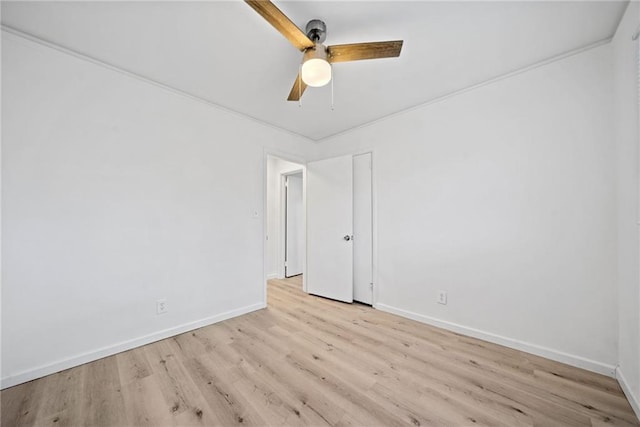 empty room with ceiling fan, ornamental molding, and light wood-type flooring