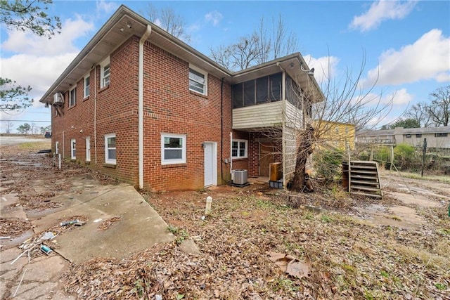 rear view of property featuring a sunroom and cooling unit