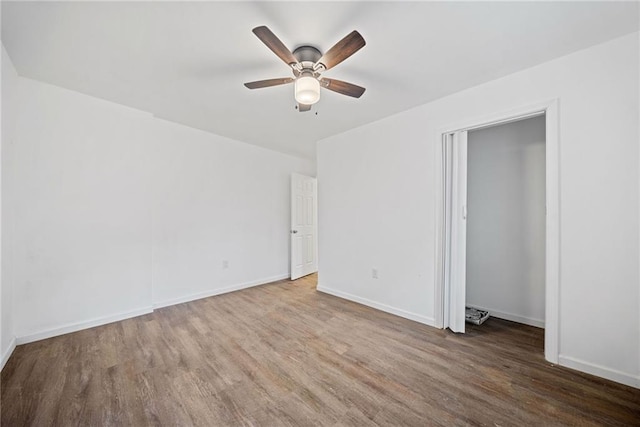 empty room featuring ceiling fan and dark hardwood / wood-style floors