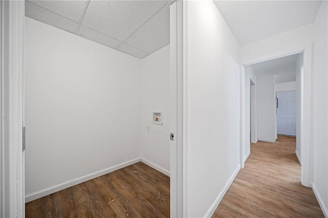 hall with hardwood / wood-style flooring and a drop ceiling