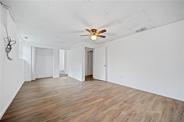 interior space featuring ceiling fan, hardwood / wood-style floors, and a drop ceiling