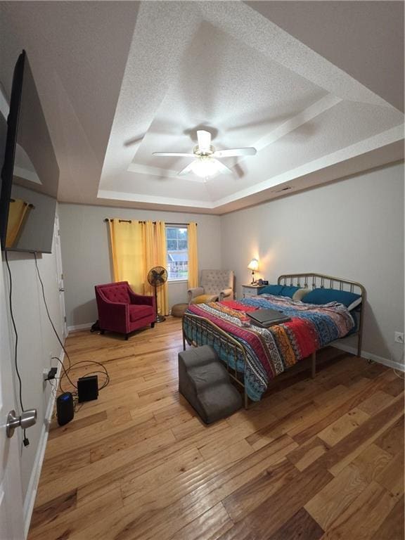77 Ben W Dr, Cedartown, GA 30125 - bedroom featuring a tray ceiling, a textured ceiling, wood finished floors, and a ceiling fan