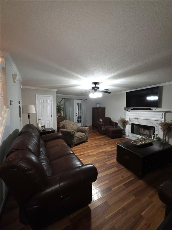 77 Ben W Dr, Cedartown, GA 30125 - living room with ornamental molding, wood finished floors, ceiling fan, a premium fireplace, and a textured ceiling