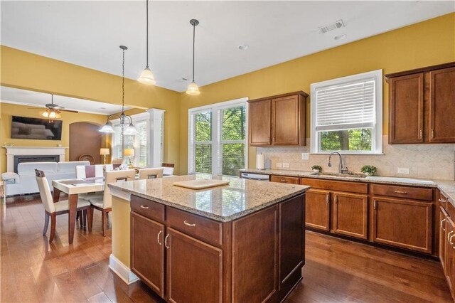 kitchen featuring a healthy amount of sunlight, a fireplace, a sink, and visible vents
