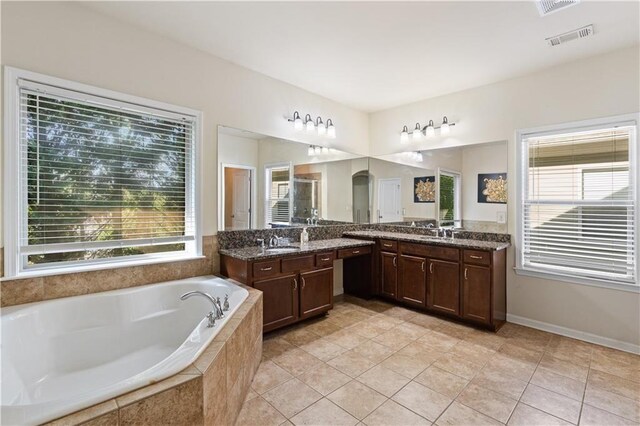 bathroom featuring a garden tub, vanity, tile patterned flooring, and visible vents