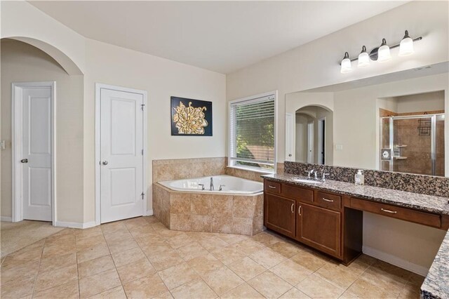 bathroom featuring a bath, a stall shower, and vanity