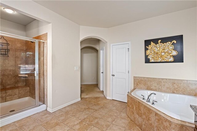 bathroom featuring tile patterned floors, a bath, and a shower stall