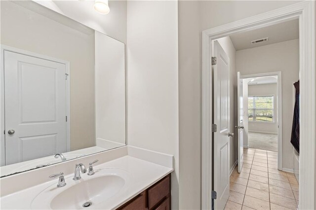 bathroom featuring tile patterned floors, vanity, baseboards, and visible vents