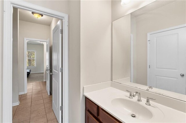 bathroom with tile patterned flooring, vanity, and baseboards