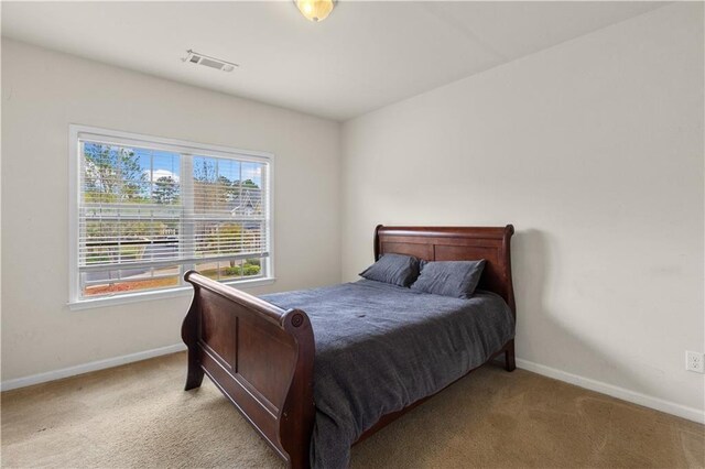 carpeted bedroom with baseboards and visible vents