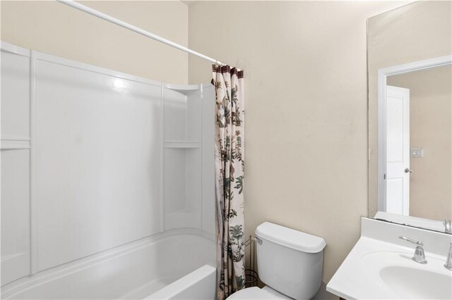 full bathroom featuring toilet, shower / bath combo with shower curtain, and vanity