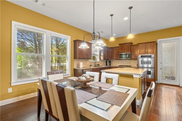 dining room with a notable chandelier, dark wood-style flooring, baseboards, and visible vents