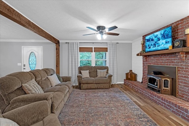 living room featuring ceiling fan, wood-type flooring, crown molding, and a textured ceiling