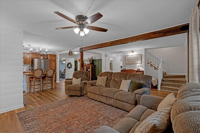 living room featuring a textured ceiling, ceiling fan, beam ceiling, and light hardwood / wood-style floors