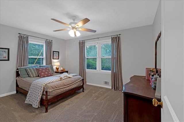 carpeted bedroom featuring ceiling fan and multiple windows