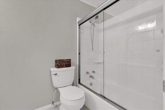 bathroom with enclosed tub / shower combo and toilet