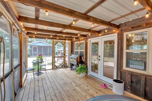 unfurnished sunroom featuring beam ceiling and french doors